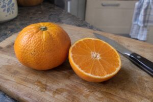 Un agrume kiyomi entier et une moitié coupée laissant voir sa chair orange.