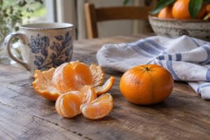 Une mandarine Satsuma Japan Seedless entière et quelques quartiers pelés sur une table.